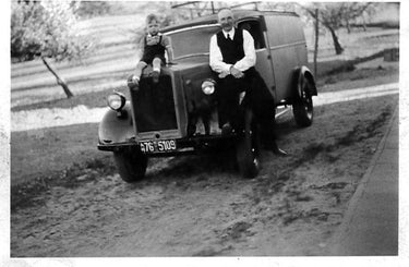 Old Picture of Engelbert und Norbert Strauss sitting on a car